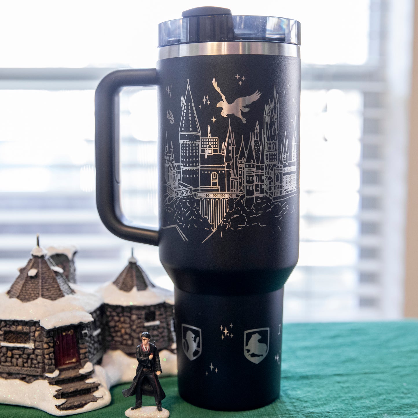 a black travel mug with a harry potter scene on it