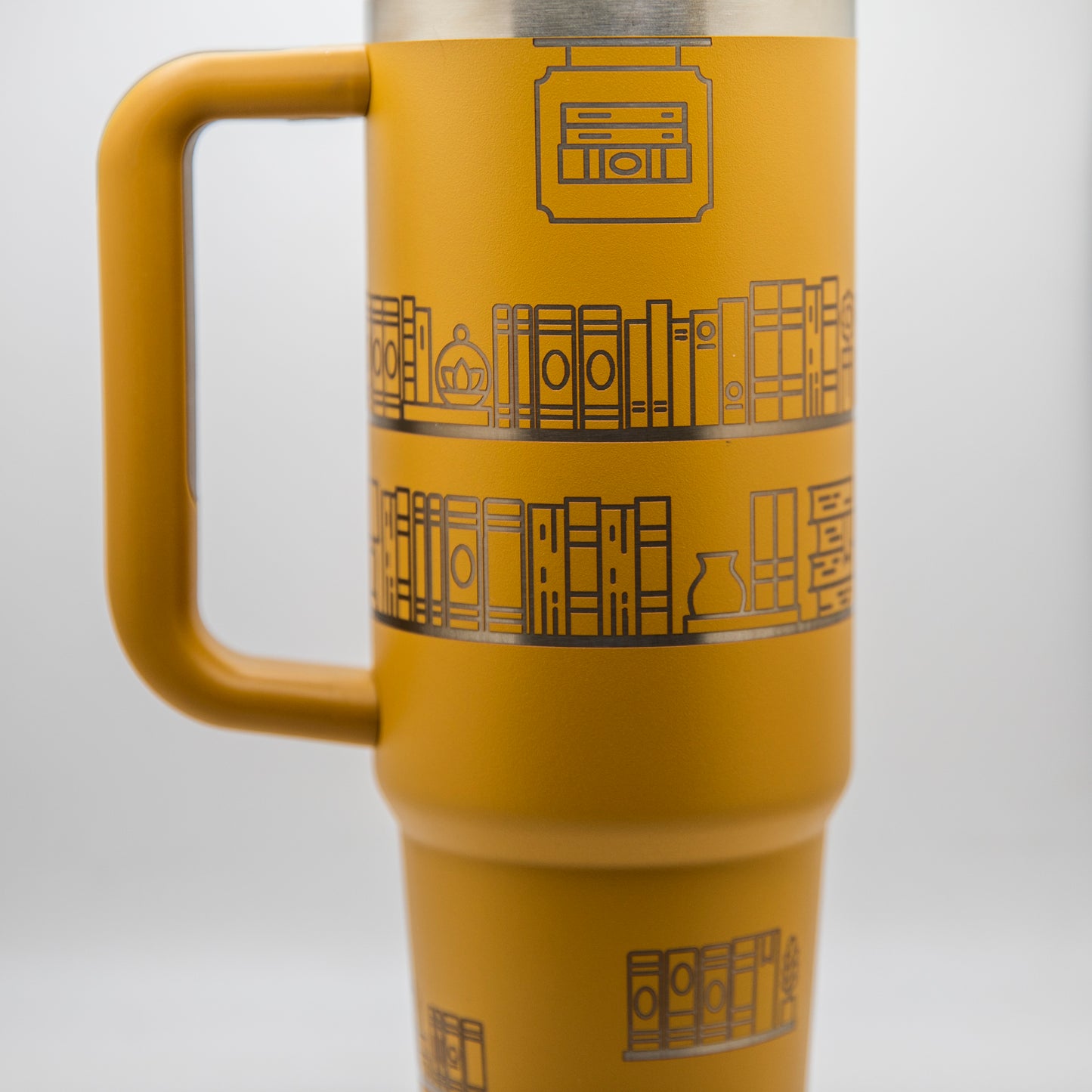 a yellow travel mug with a design on it