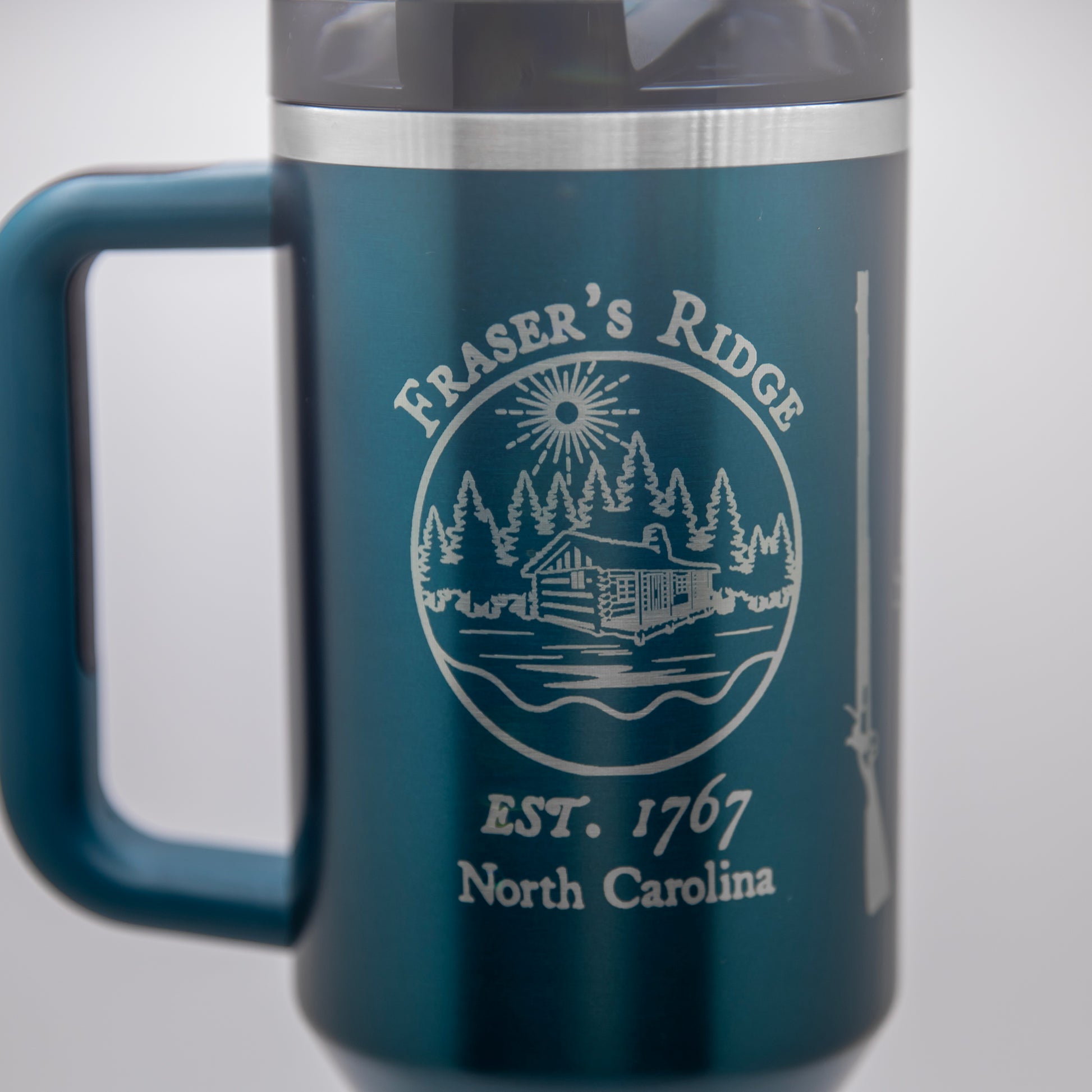 a stainless steel travel mug with a blue handle