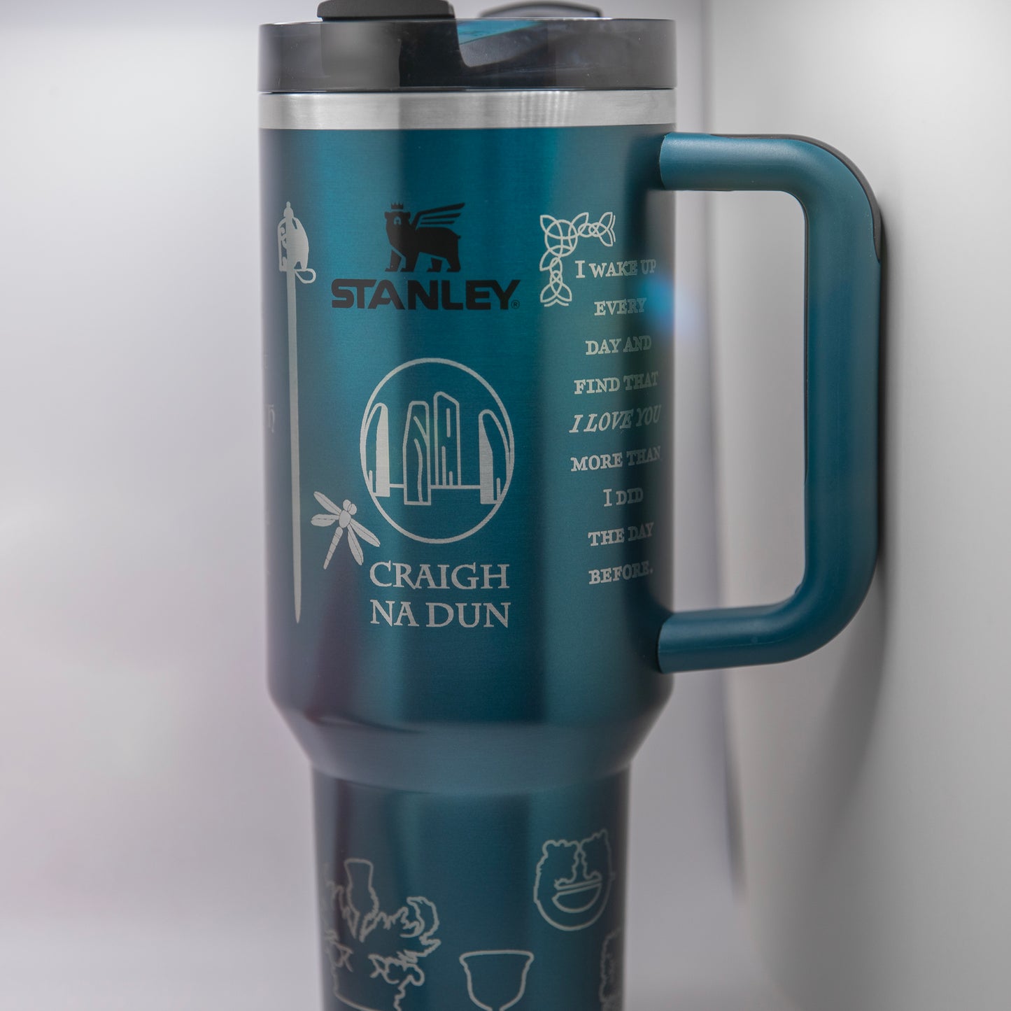 a stainless steel travel mug with a blue handle