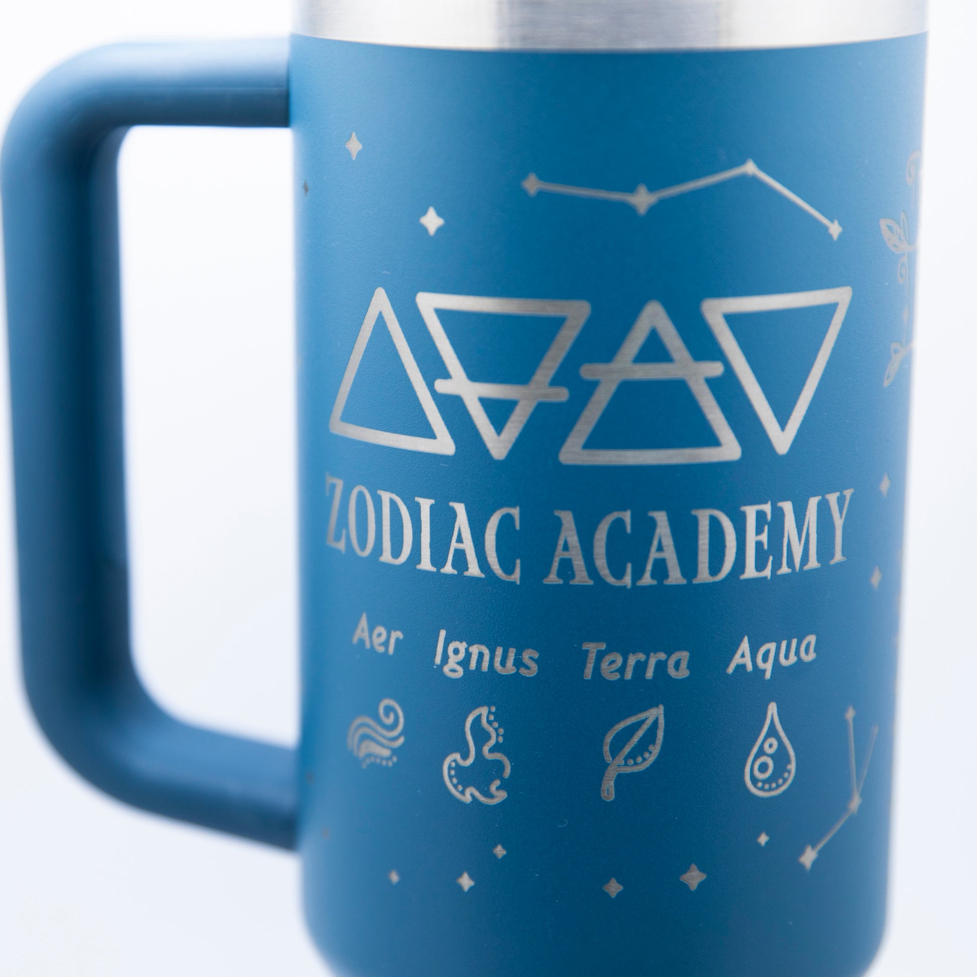 a blue travel mug with zodiac symbols on it