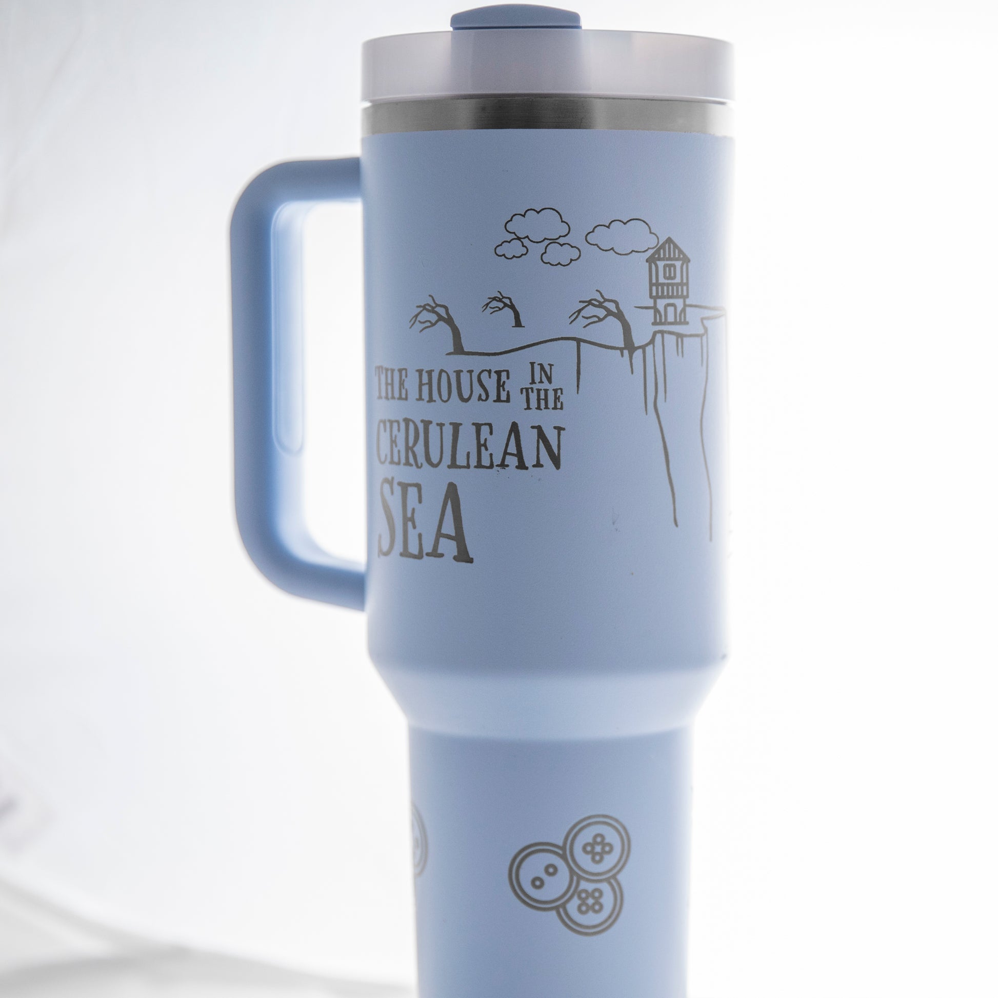 a white travel mug with a blue handle