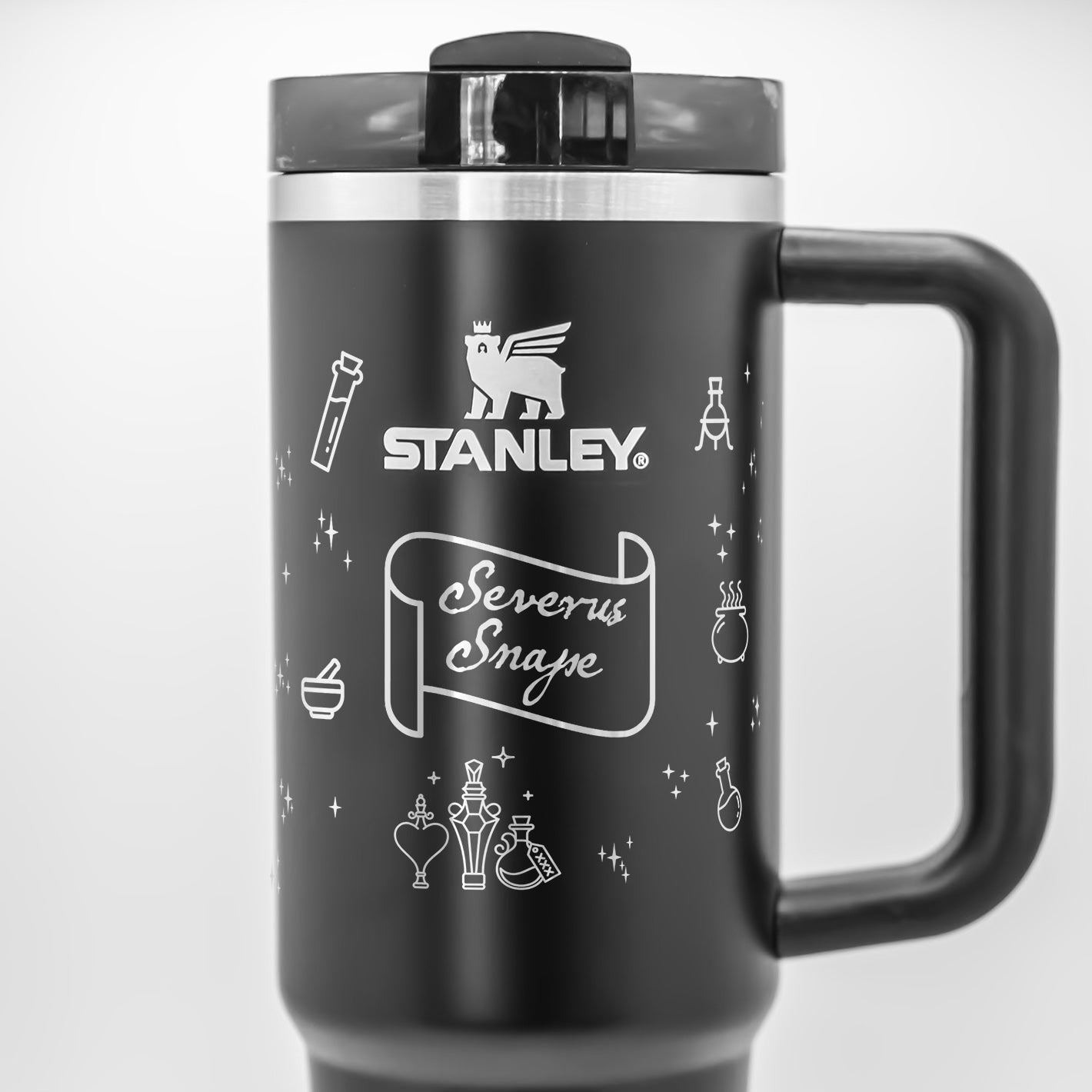 a stainless steel travel mug with a black handle