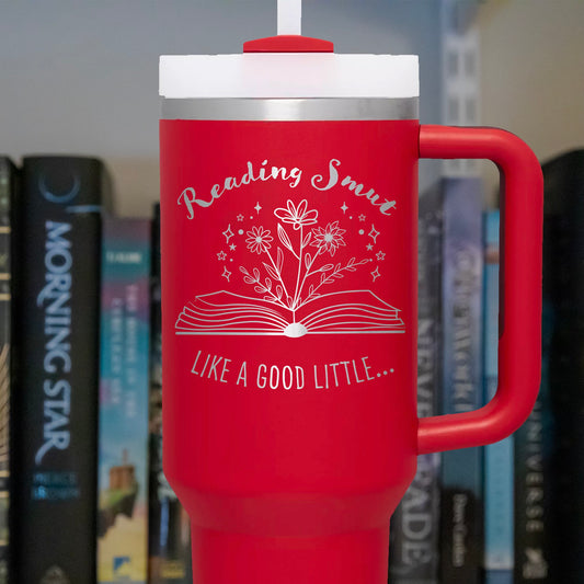 a red coffee mug with a book on top of it