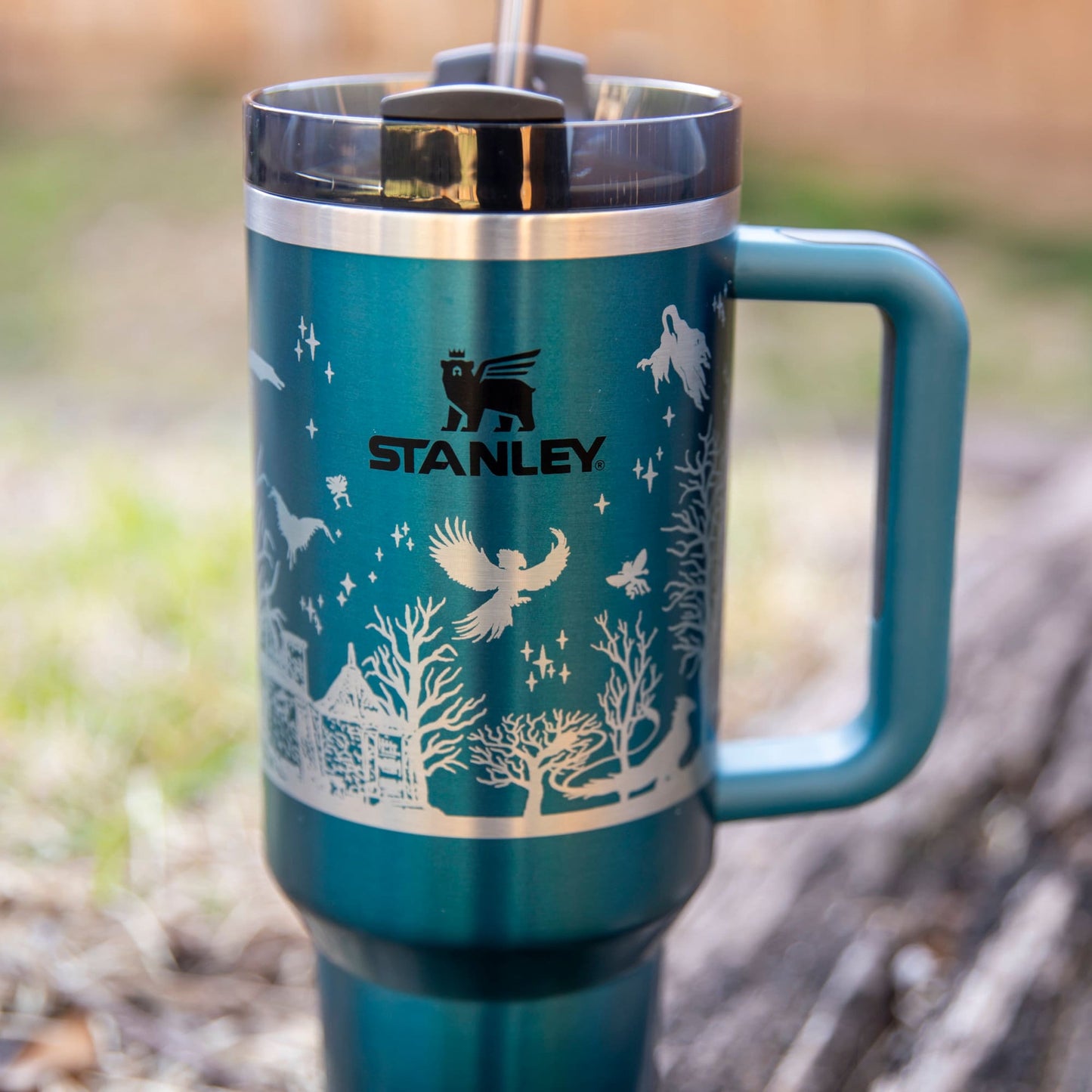 a stainless steel travel mug with a blue handle