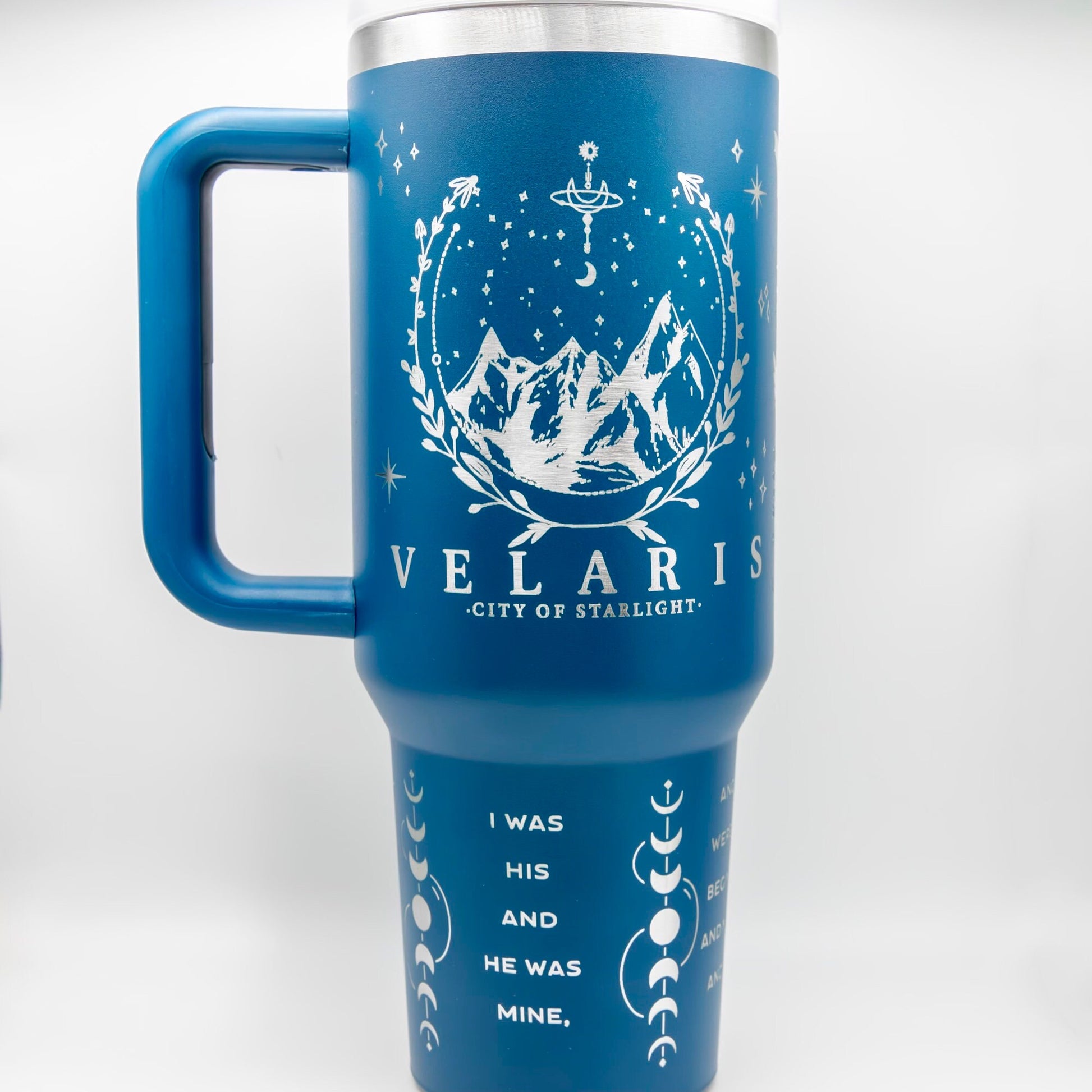 a blue travel mug with a mountain scene on it