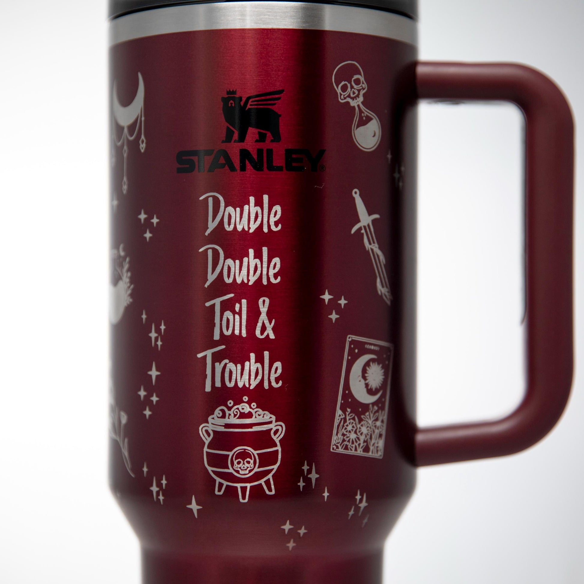 a red travel mug with doodle, double, tail and trouble written on it