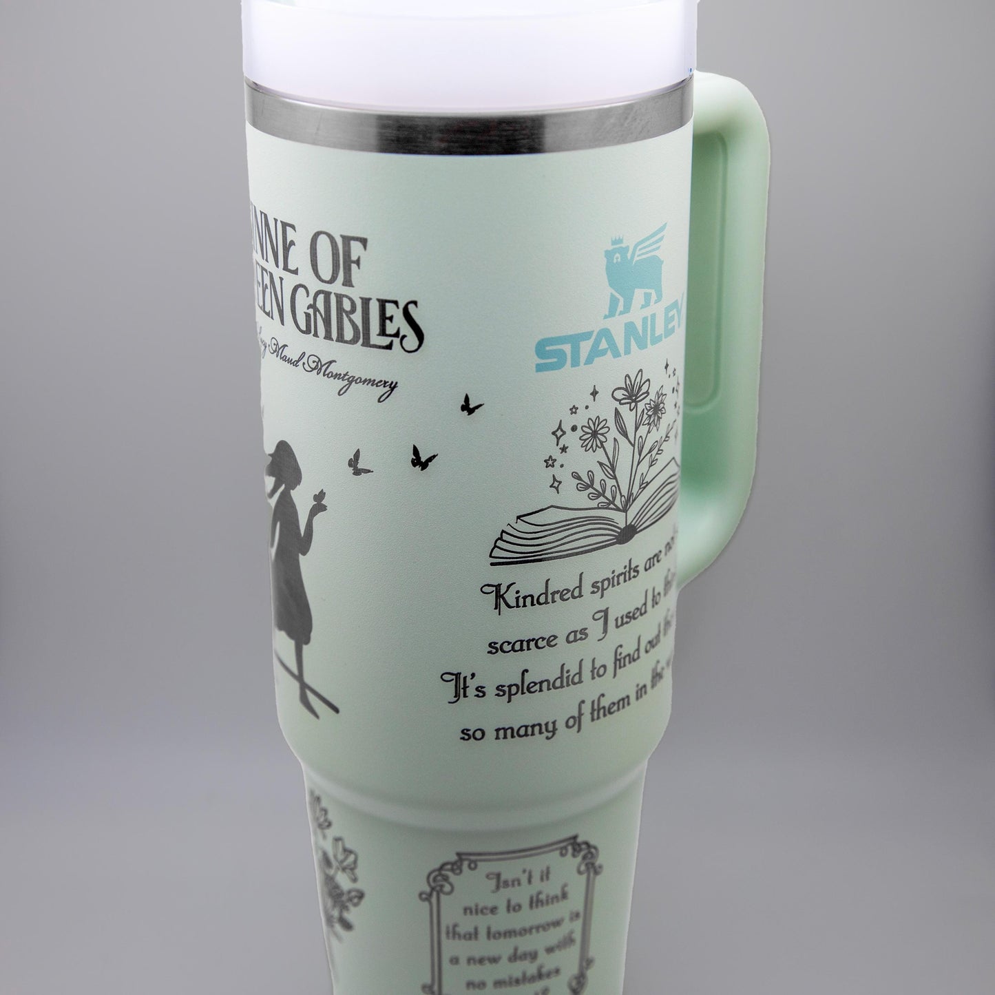 a travel mug with a picture of a woman holding a book