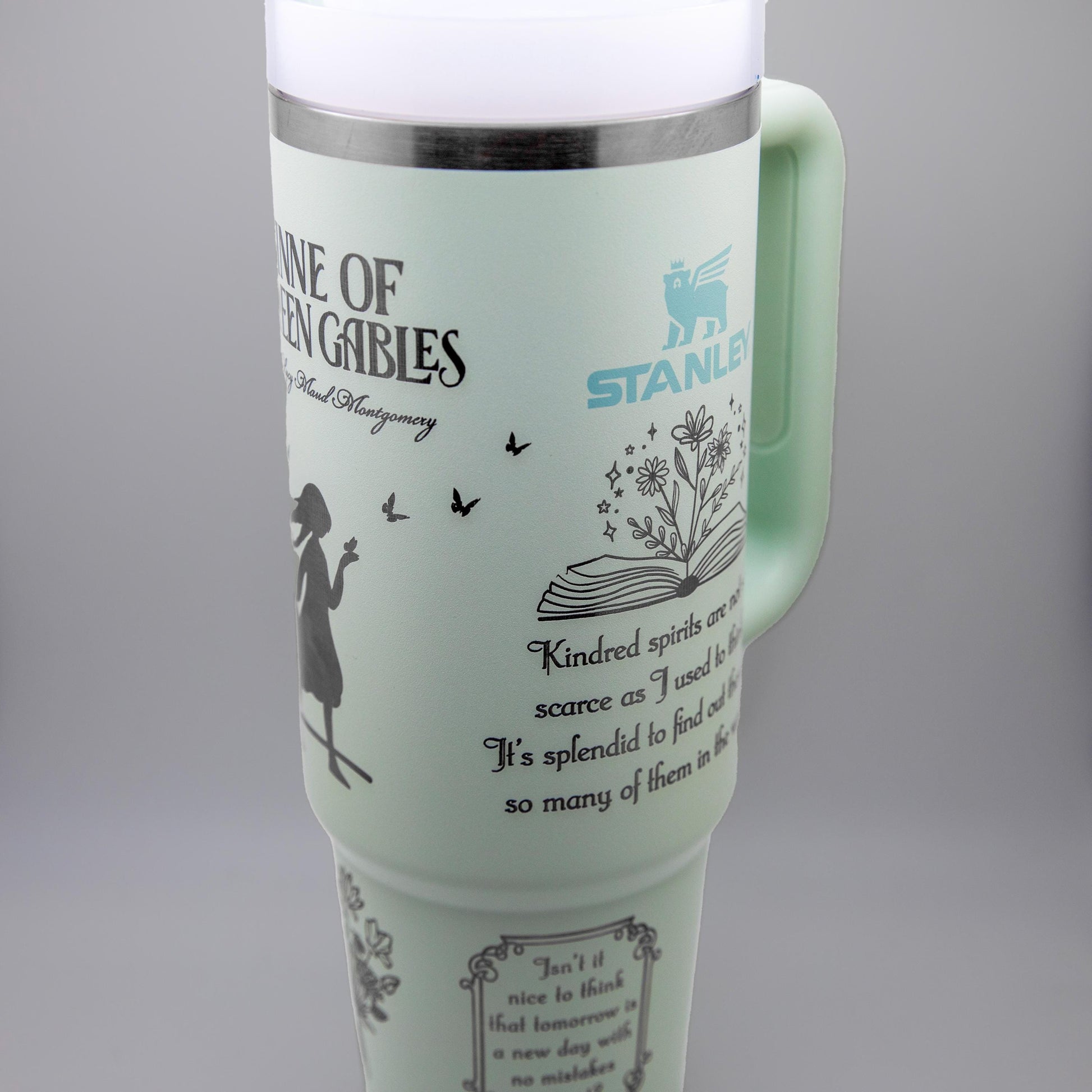 a travel mug with a picture of a woman holding a book