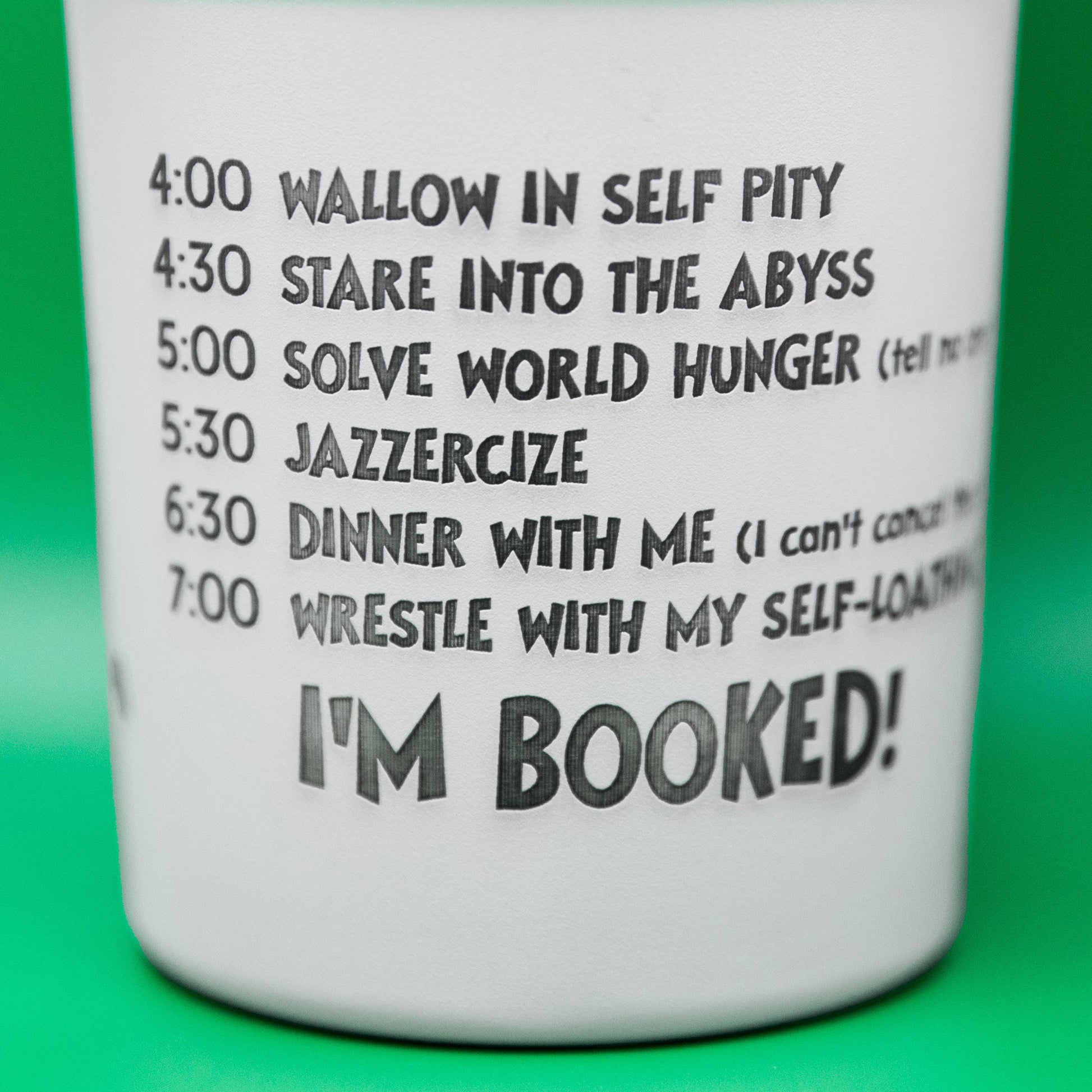 a white cup with words on it on a green background