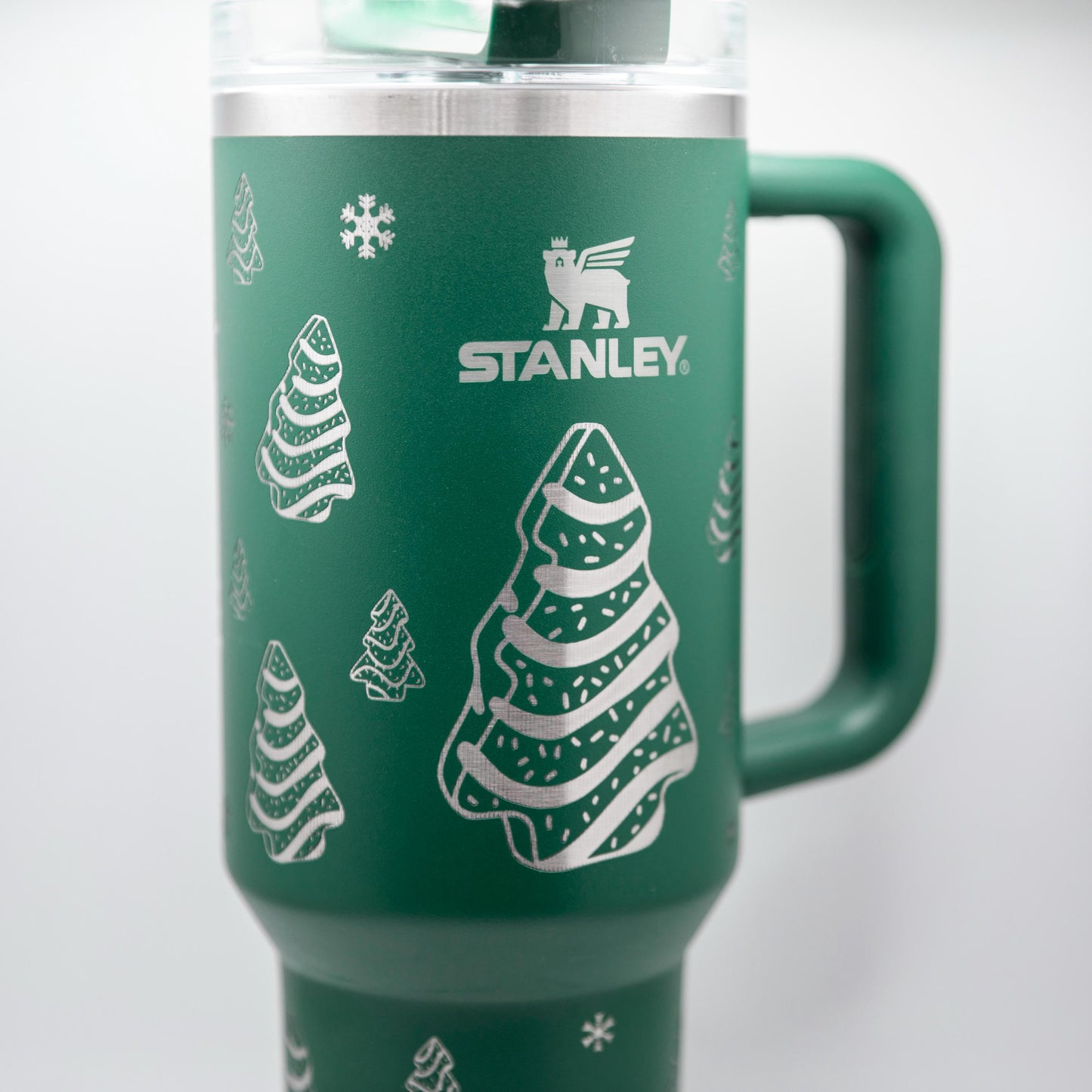 a green travel mug with a christmas tree on it