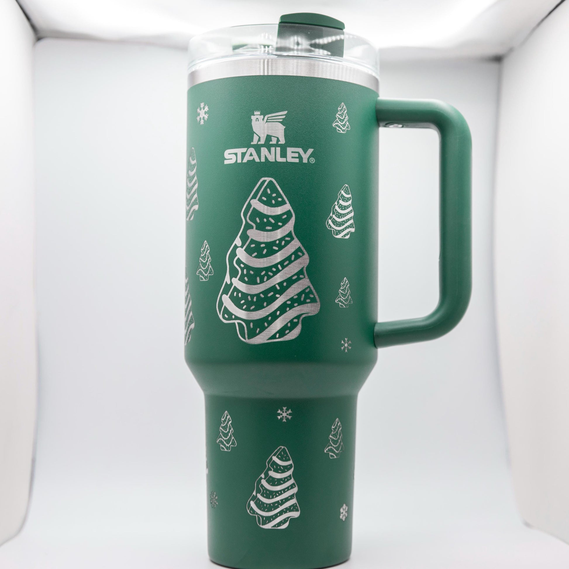 a green travel mug with a christmas tree on it