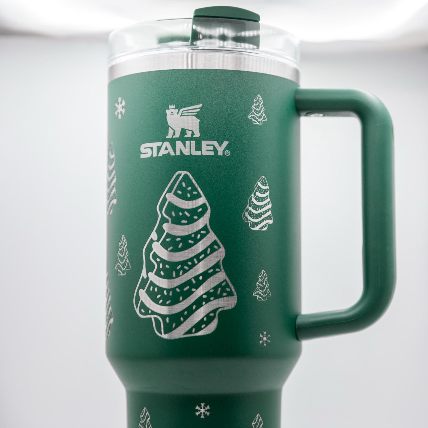 a green travel mug with a christmas tree on it