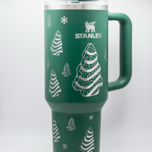 a green travel mug with a christmas tree on it